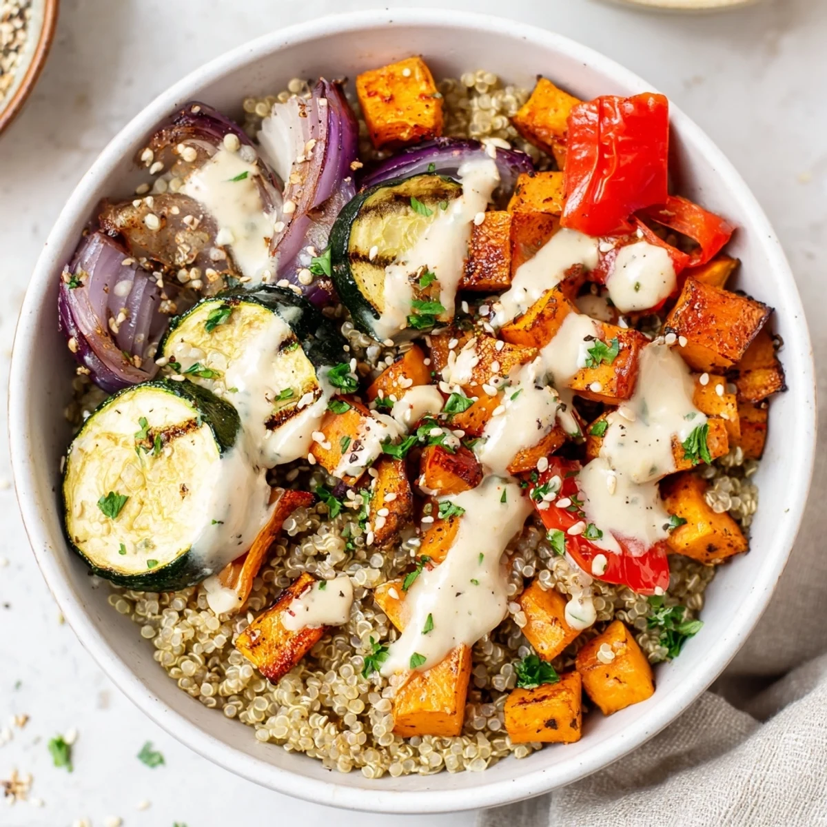 Hearty Roasted Vegetable Quinoa Bowl with Tahini features caramelized veggies and toasted sesame seeds for a satisfying vegan meal.