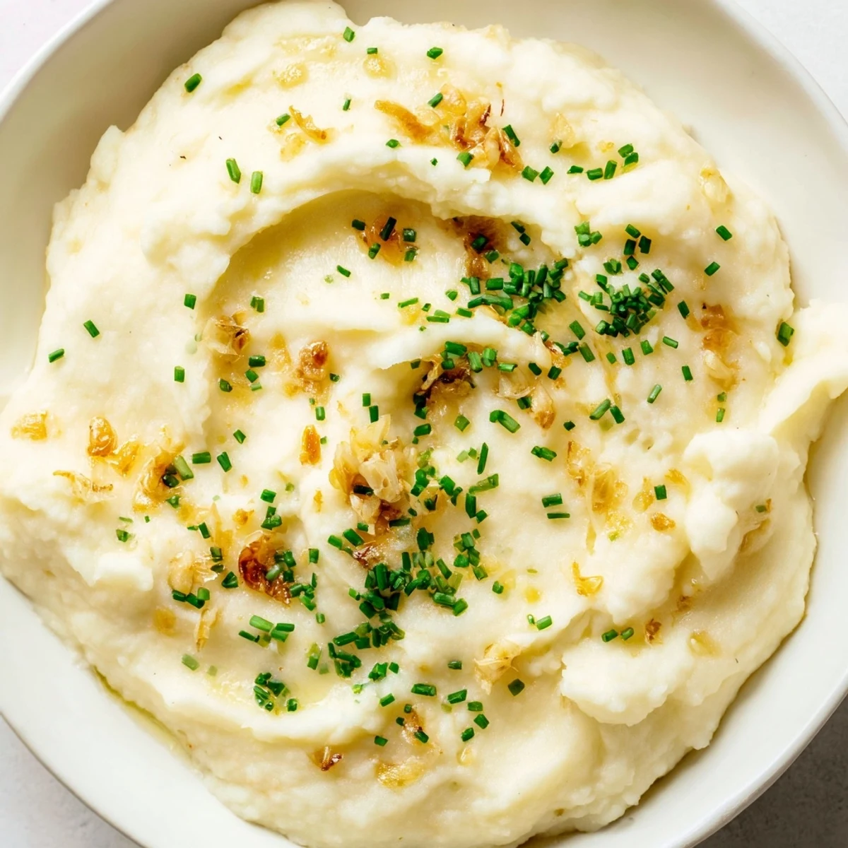 Smooth and fluffy roasted garlic mashed cauliflower served warm as a healthy alternative to mashed potatoes.