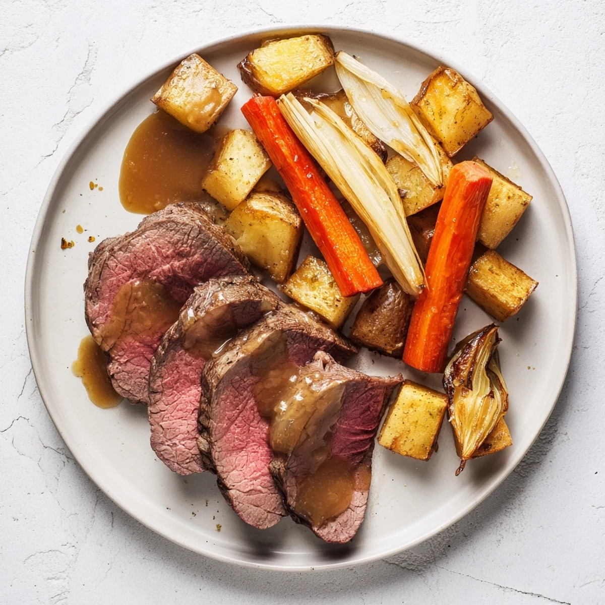 Close-up of a sizzling Beef Supper Roast Dinner with garlic-herb crusted beef, caramelized onion wedges, and steaming beef gravy poured over the vegetables.