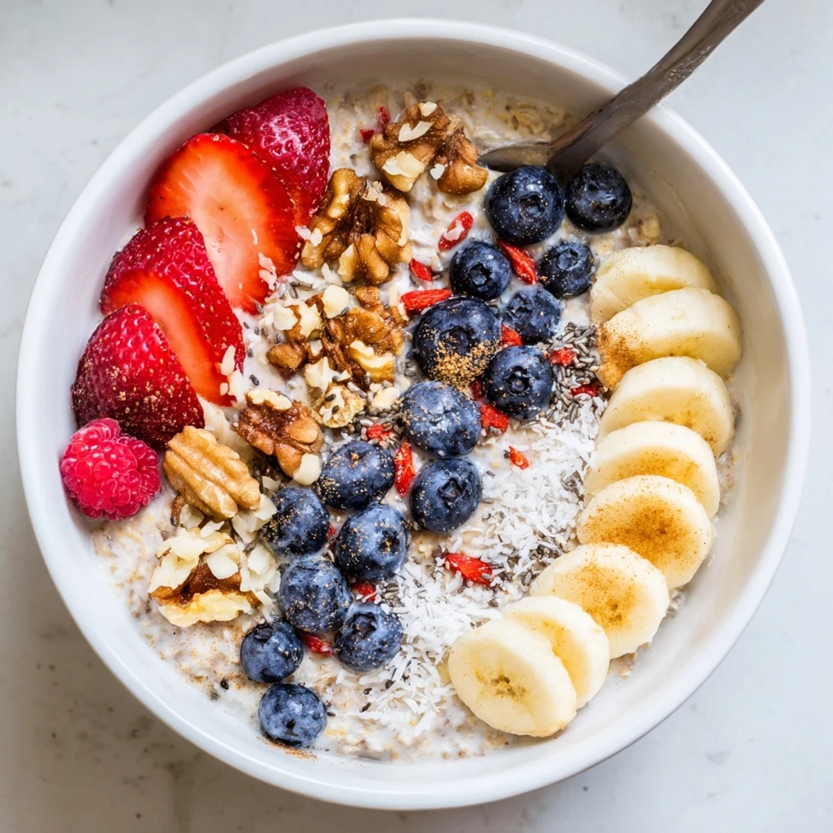 Overhead view of Creamy Breakfast Oats Bowl with chia seeds, coconut flakes, and mixed berries for a healthy start.