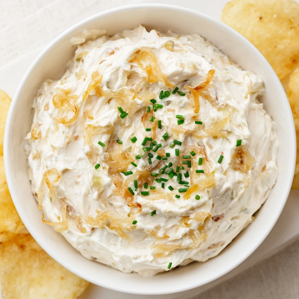 Savory Game Day Onion Dip in a ceramic bowl, paired with a pile of kettle-cooked potato chips, perfect for Super Bowl gatherings.