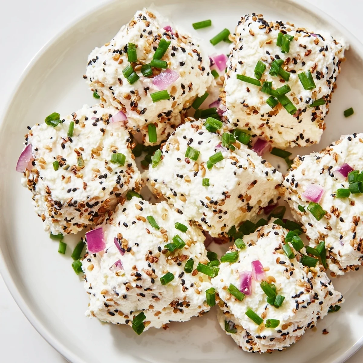 A close-up of Everything Bagel Cottage Cheese Bites reveals a creamy, dotted texture from chives and onion, perfect for an easy, high-protein appetizer.