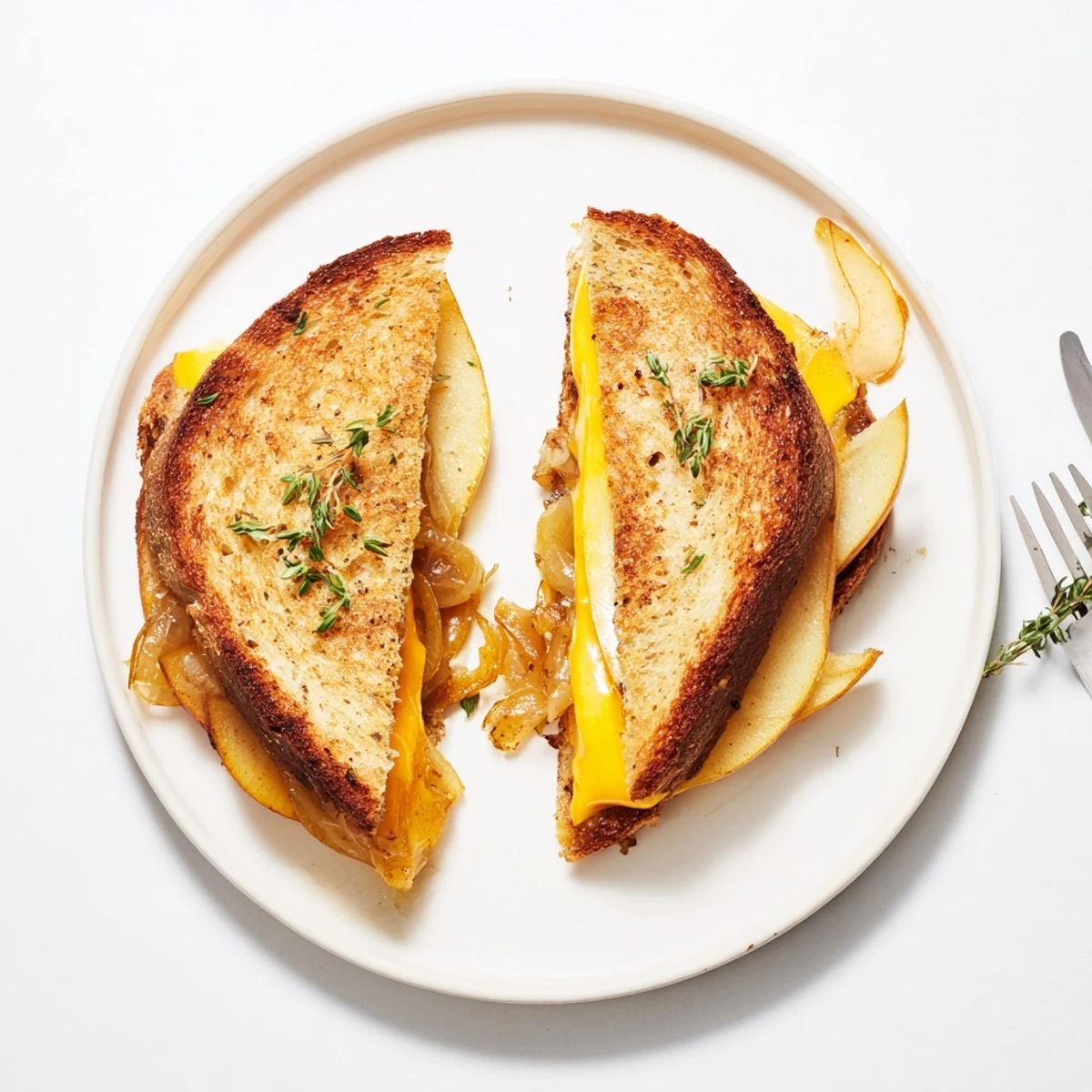 Golden-brown sourdough slices overflowing with melted cheddar, sweet pear and apple slices, and rich caramelized onions for the Pear, Apple & Grilled Cheese with Caramelized Onions.