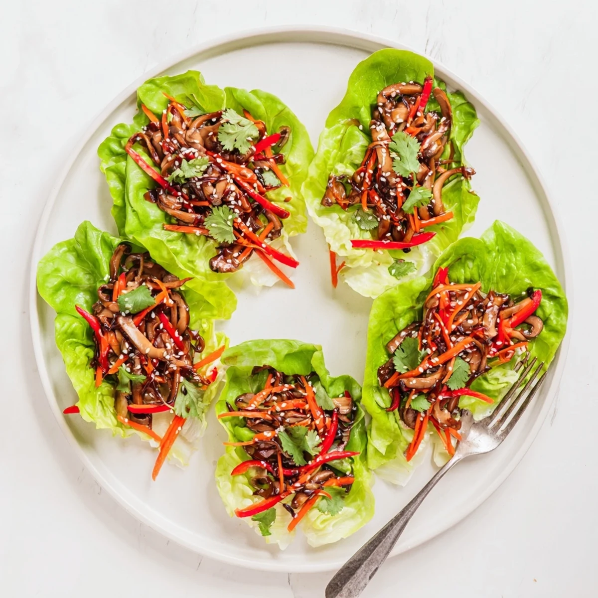 Savory Shiitake Mushroom Lettuce Wraps served warm with a drizzle of sesame sauce.