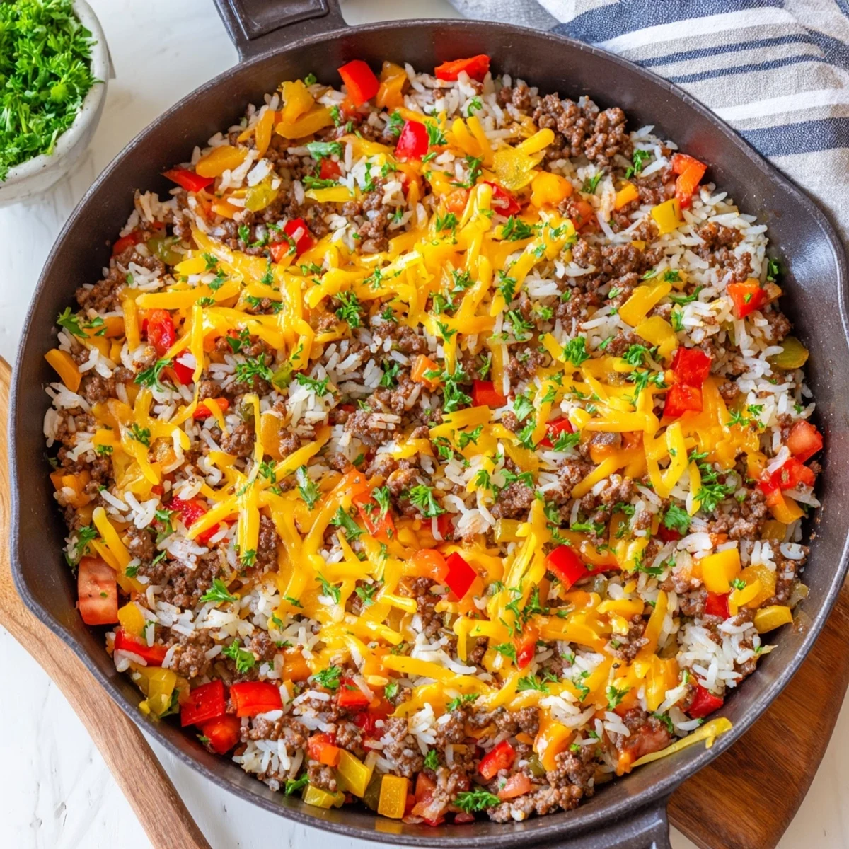 Skillet of Unstuffed Pepper Skillet with melted cheese, ground beef, rice, and colorful peppers.