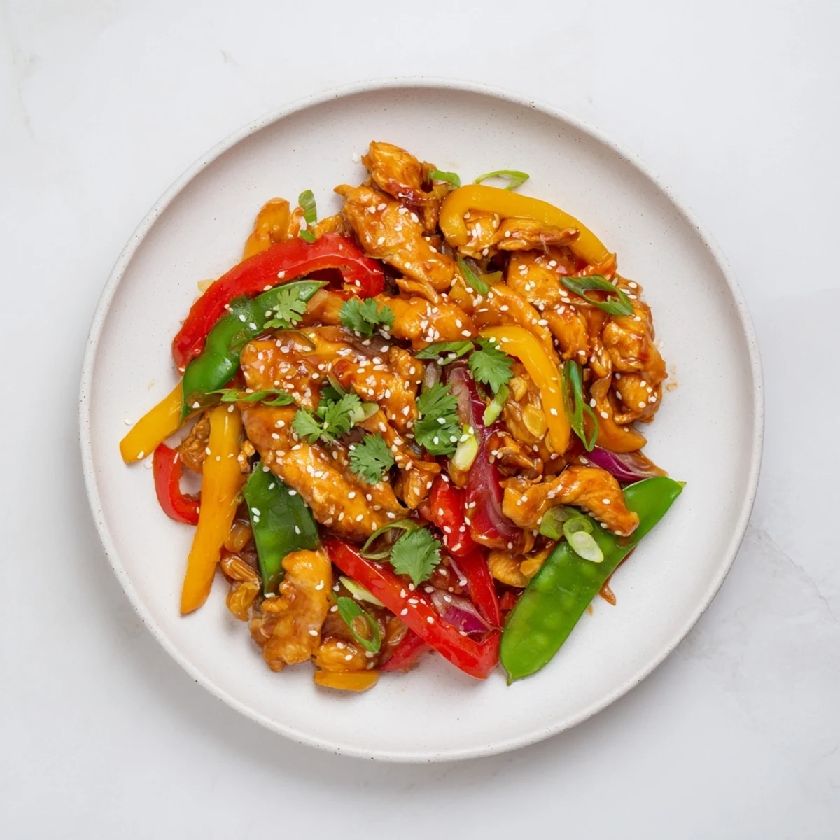 Sizzling Quick Sweet Chilli Chicken Stir Fry in a pan, featuring tender chicken, crunchy veggies, and a glossy glaze, paired with chopsticks ready to eat.