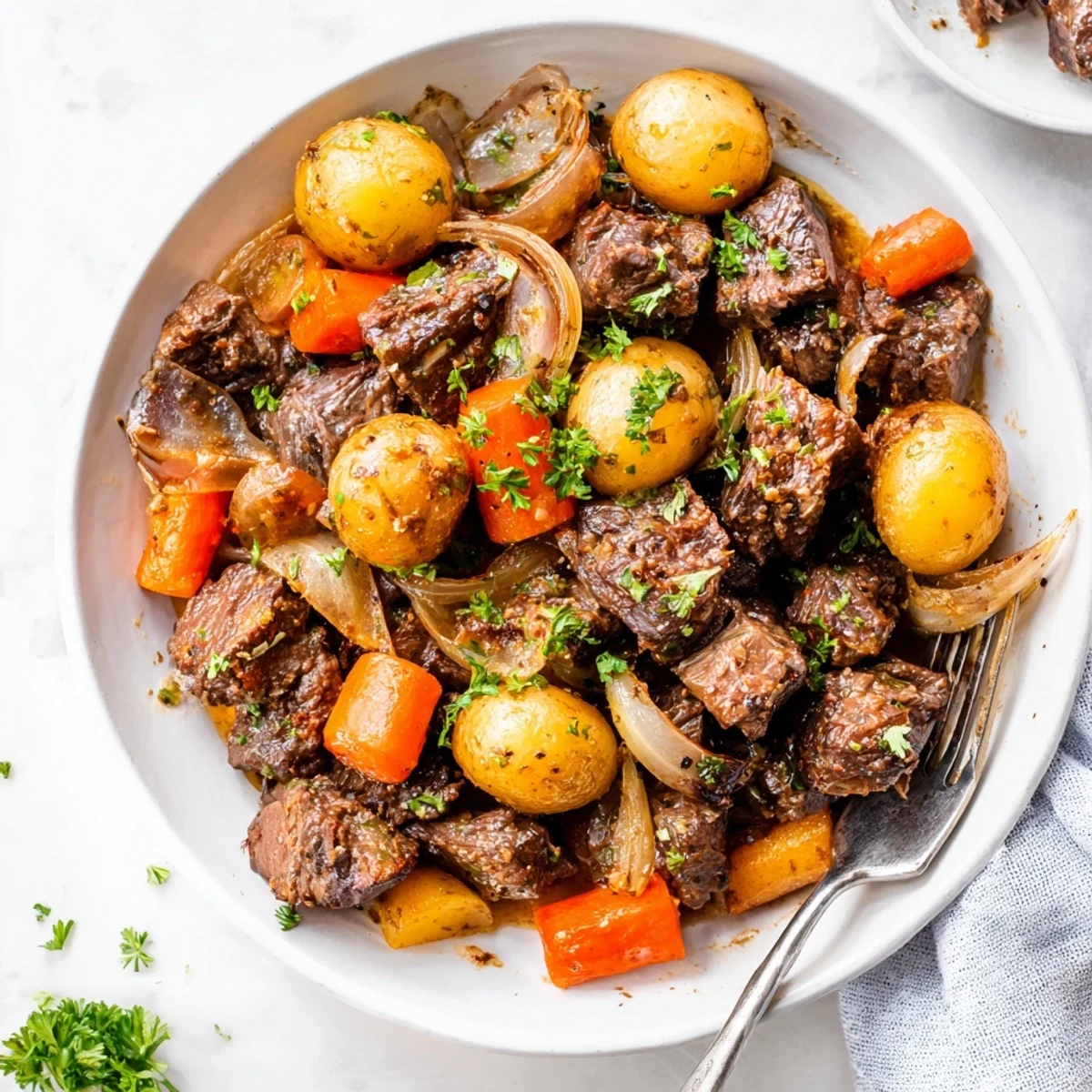 Top-down view of a slow cooker filled with Slow Cooker Garlic Butter Beef With Potatoes, steaming and ready to serve.