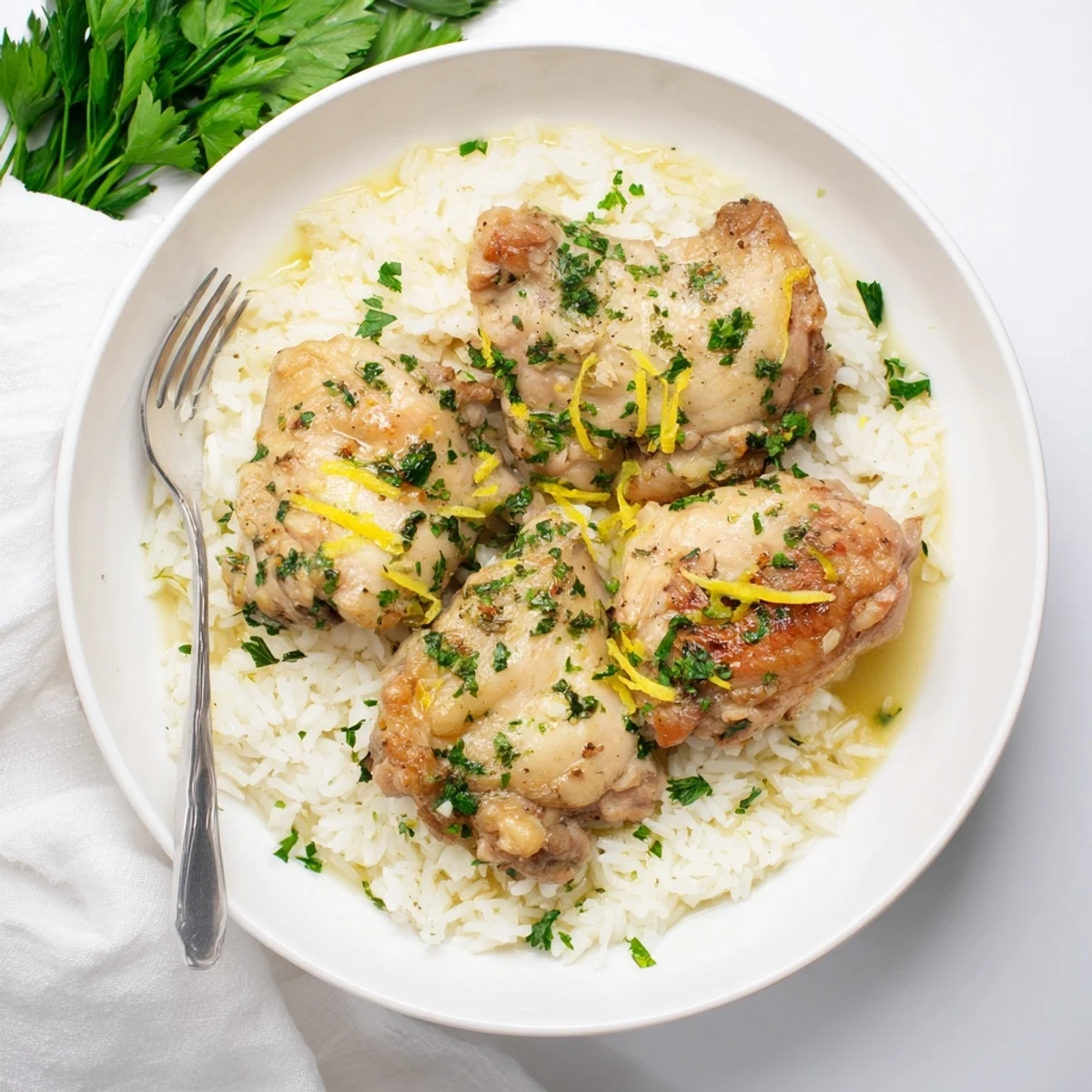 Slow Cooker Lemon Herb Chicken with Fluffy Rice served in a white bowl with herbs.