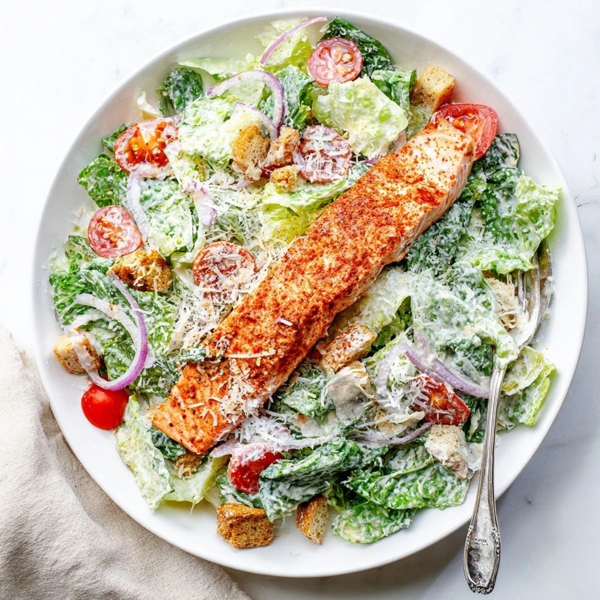 Succulent grilled salmon atop a vibrant Caesar salad, perfect for an easy, healthy lunch or dinner.