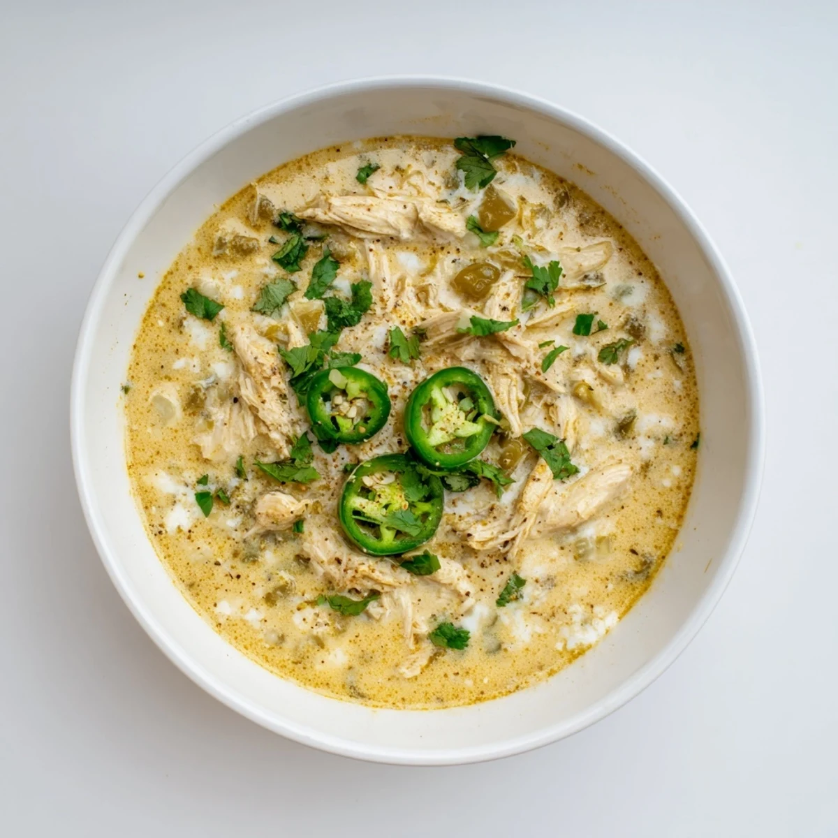Creamy white chicken chili topped with fresh cilantro in a rustic bowl
