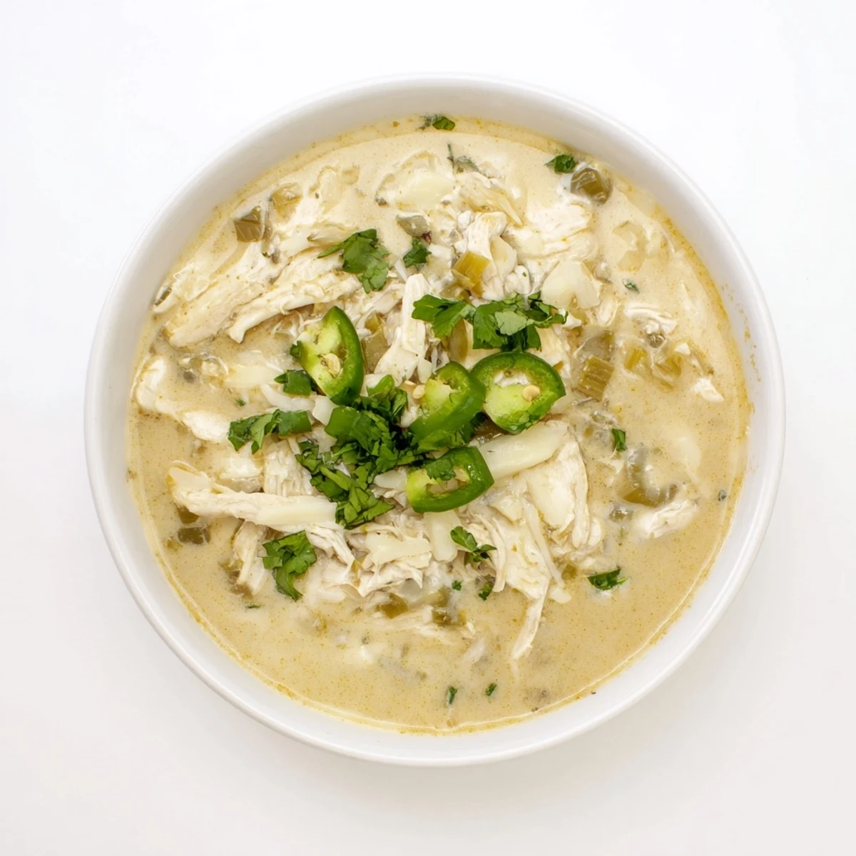 Steamy keto white chicken chili with shredded chicken and melted Monterey Jack cheese