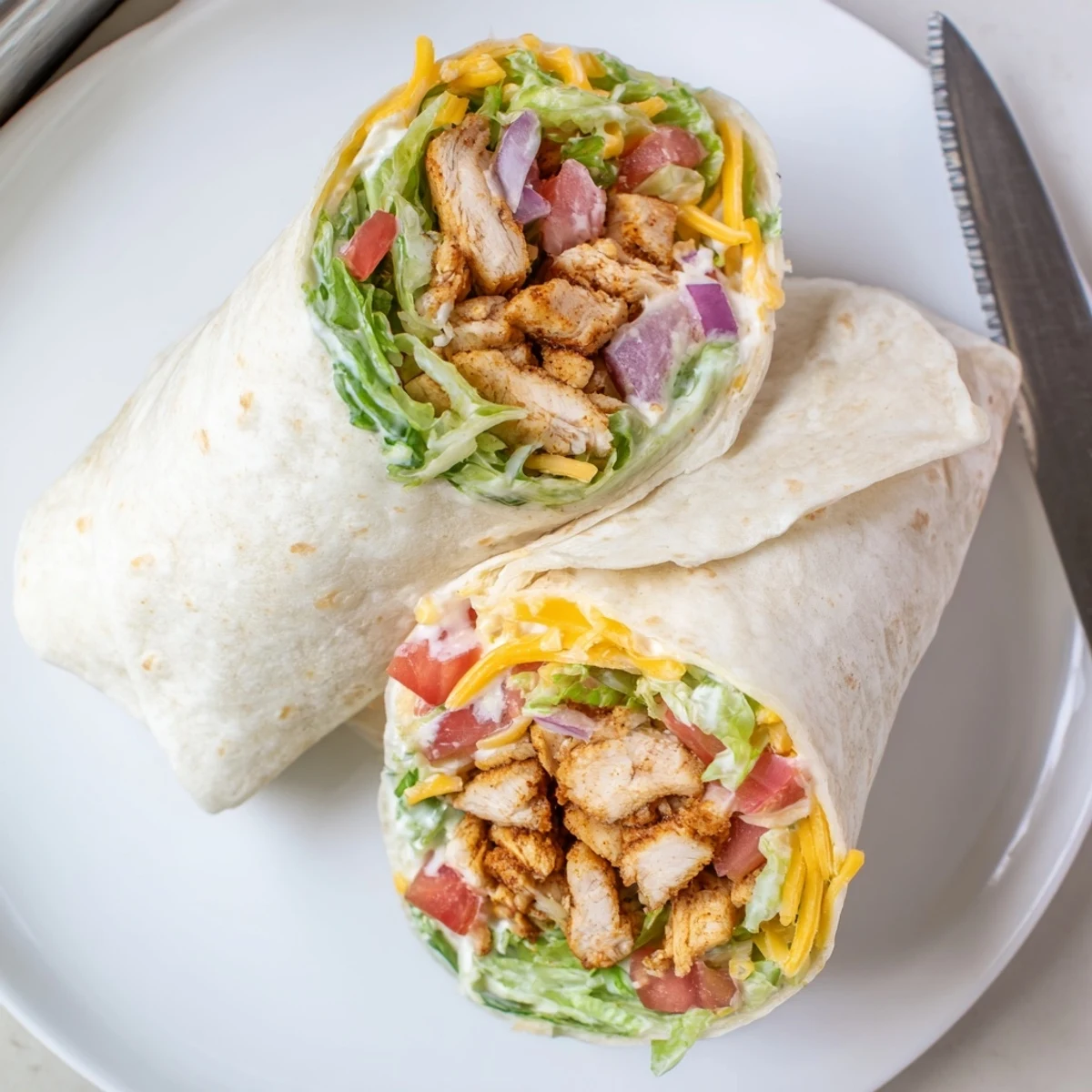 Golden cheesy garlic chicken wraps filled with melted cheddar and fresh crisp vegetables