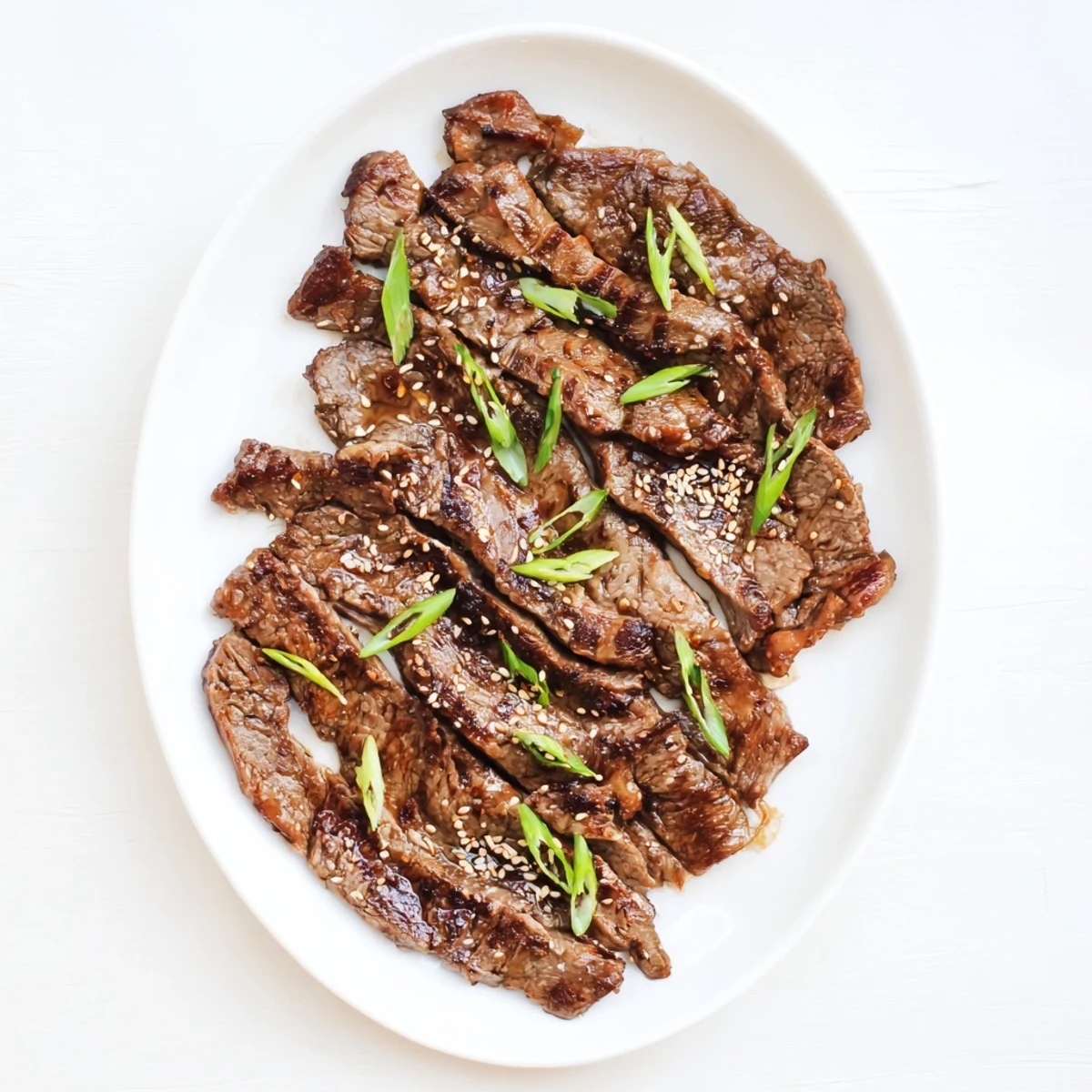 Sizzling Korean Galbi short ribs featuring smoky grill marks and toasted sesame seed topping