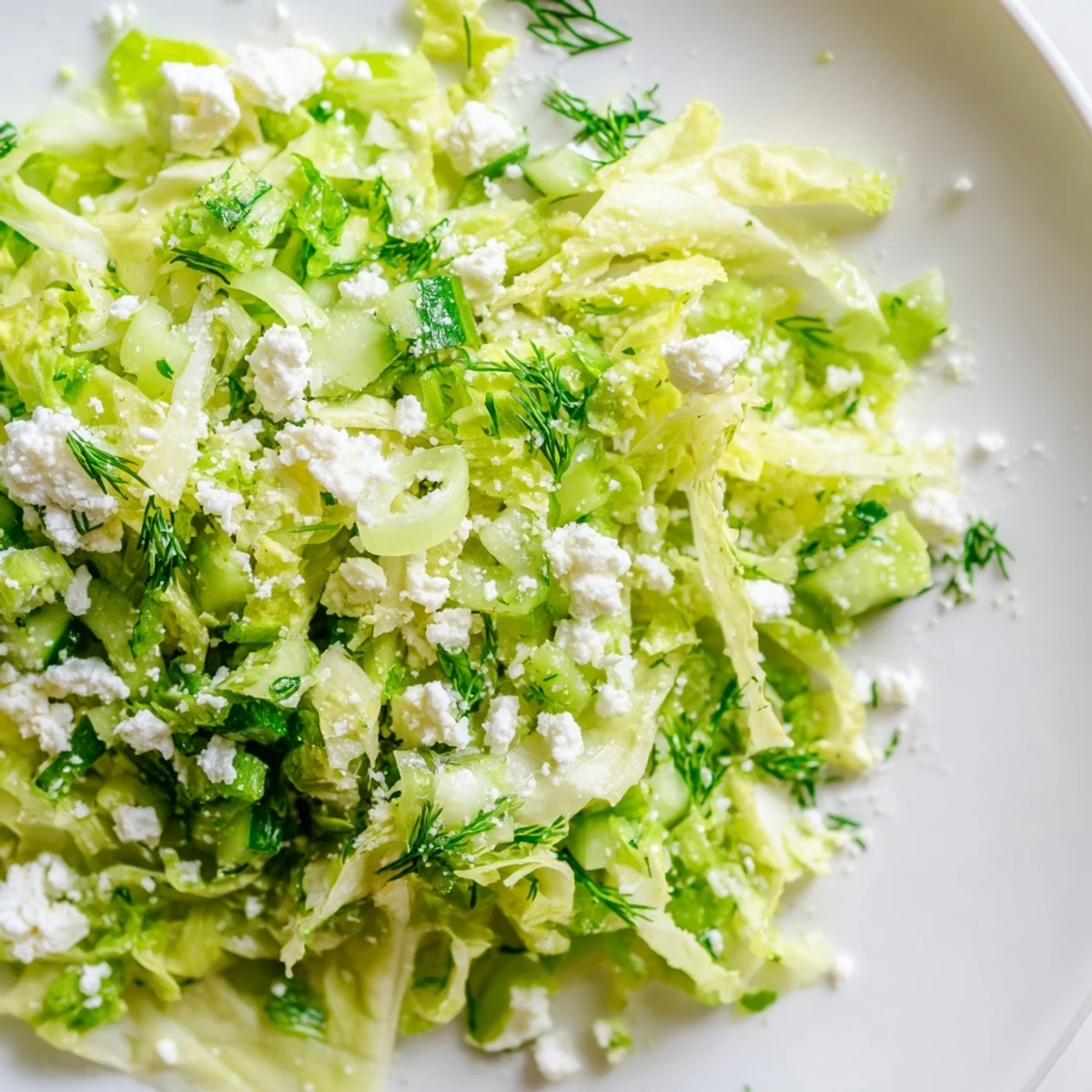 Close-up of Maroulosalata Greek salad topped with crumbled feta and fresh chopped herbs