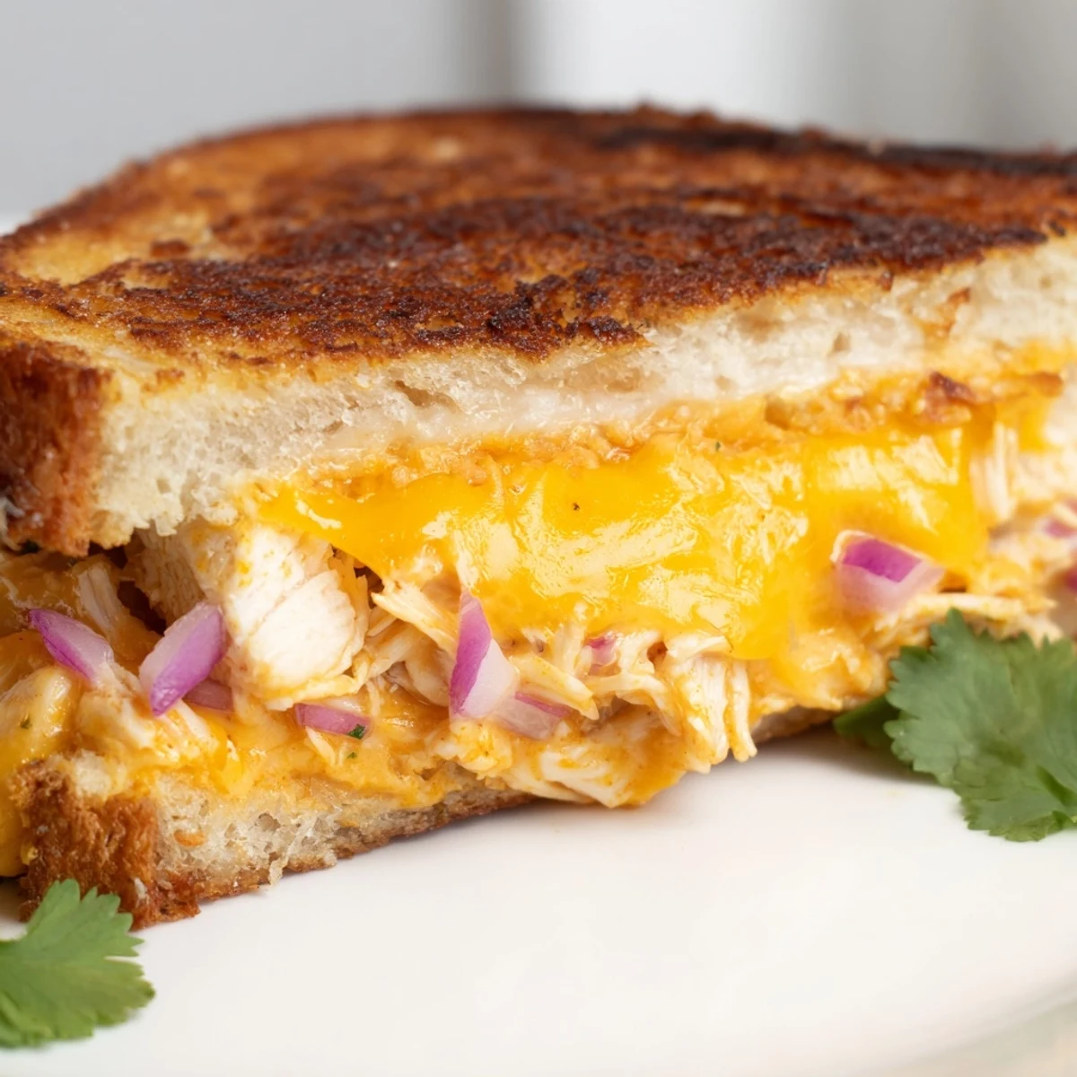 Sliced BBQ chicken grilled cheese sandwich displaying tender shredded chicken in tangy sauce layered between toasted golden bread slices