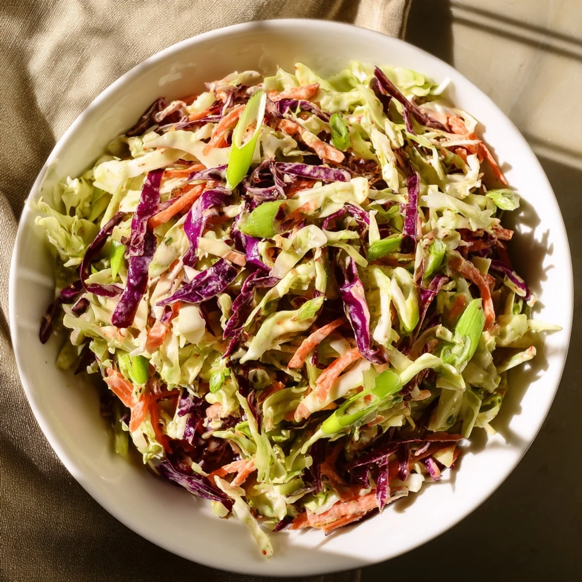 Golden grated carrot and purple cabbage blend in this easy creamy coleslaw with fresh herbs.