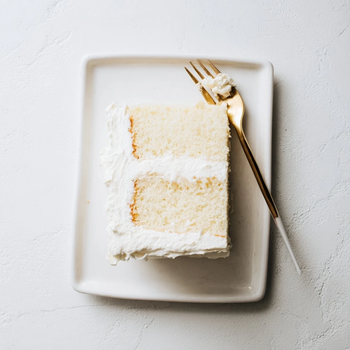 Fluffy vanilla church cake with smooth white frosting sliced for serving at gatherings