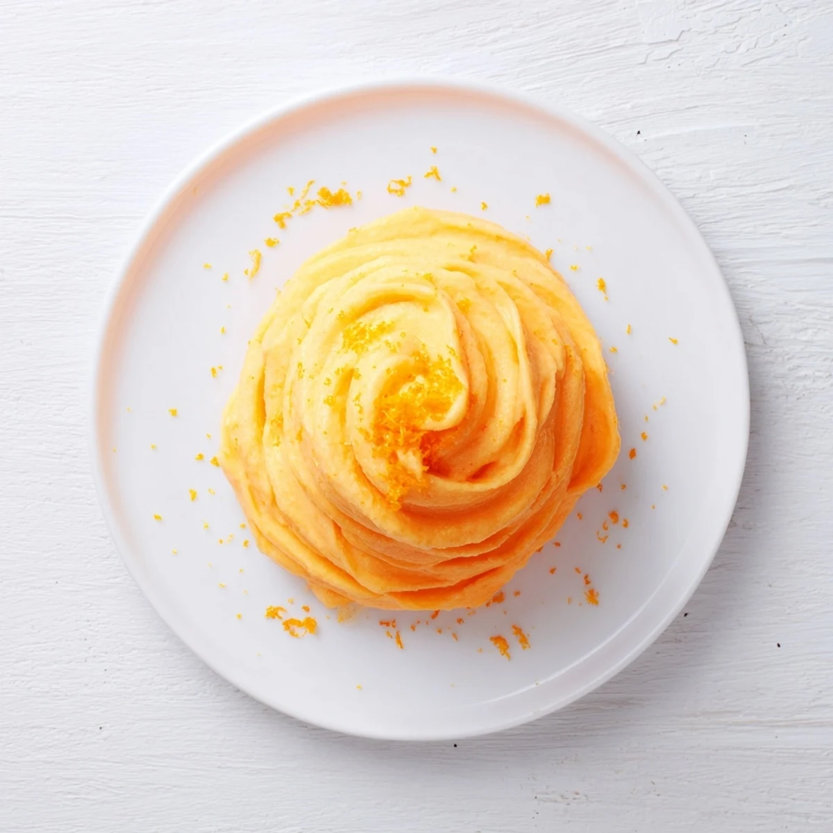 Creamy homemade orange Dole Whip swirled in a bowl with bright orange zest garnish