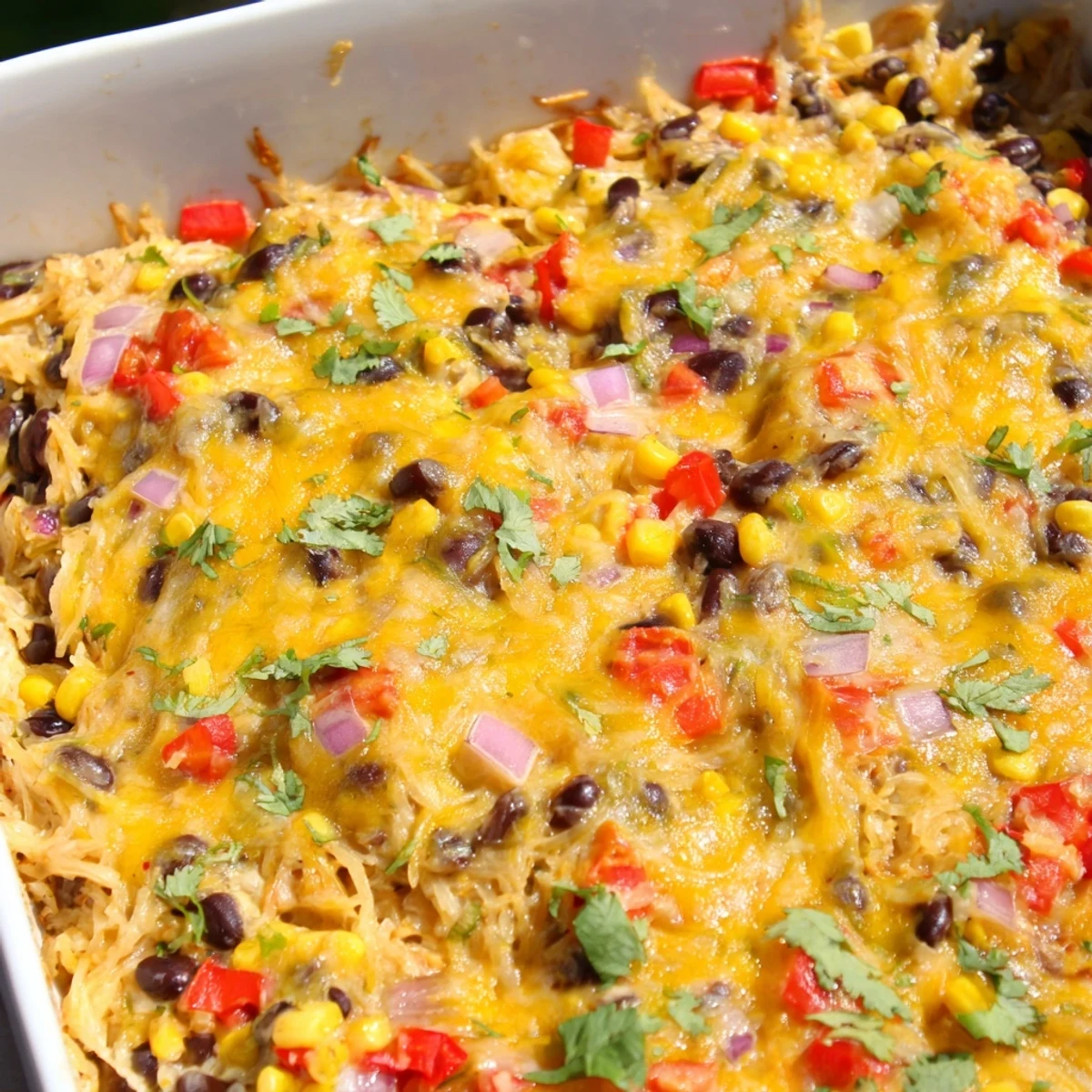 Golden cheesy Mexican spaghetti squash casserole topped with fresh cilantro and lime wedges