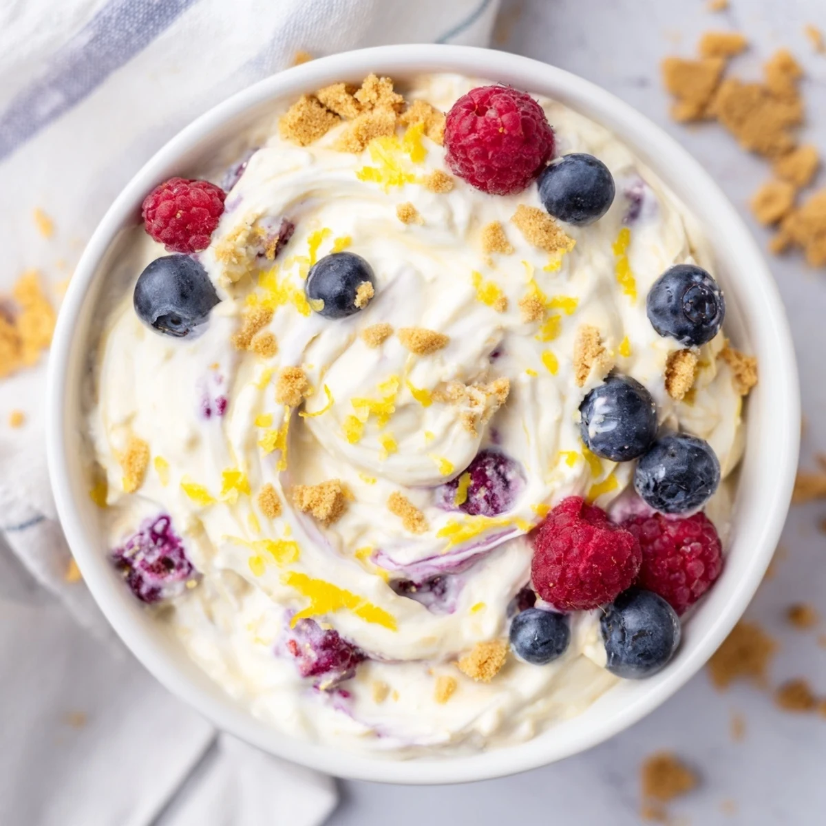 Spoonful of zesty lemon cheesecake overnight oats showing thick creamy texture with graham cracker crunch and fresh fruit topping