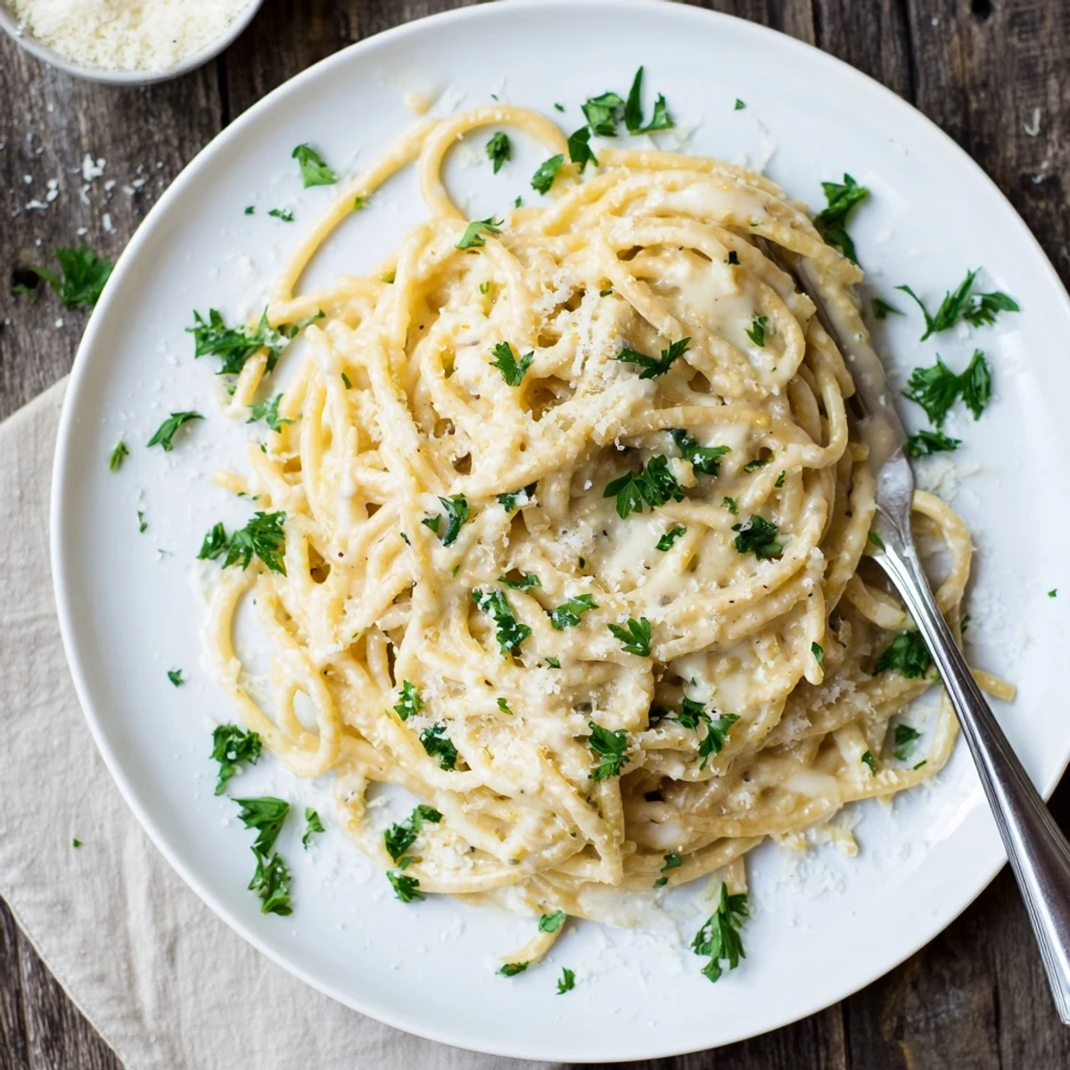 Golden cheesy garlic Parmesan spaghetti tossed in a creamy white sauce and garnished with fresh parsley