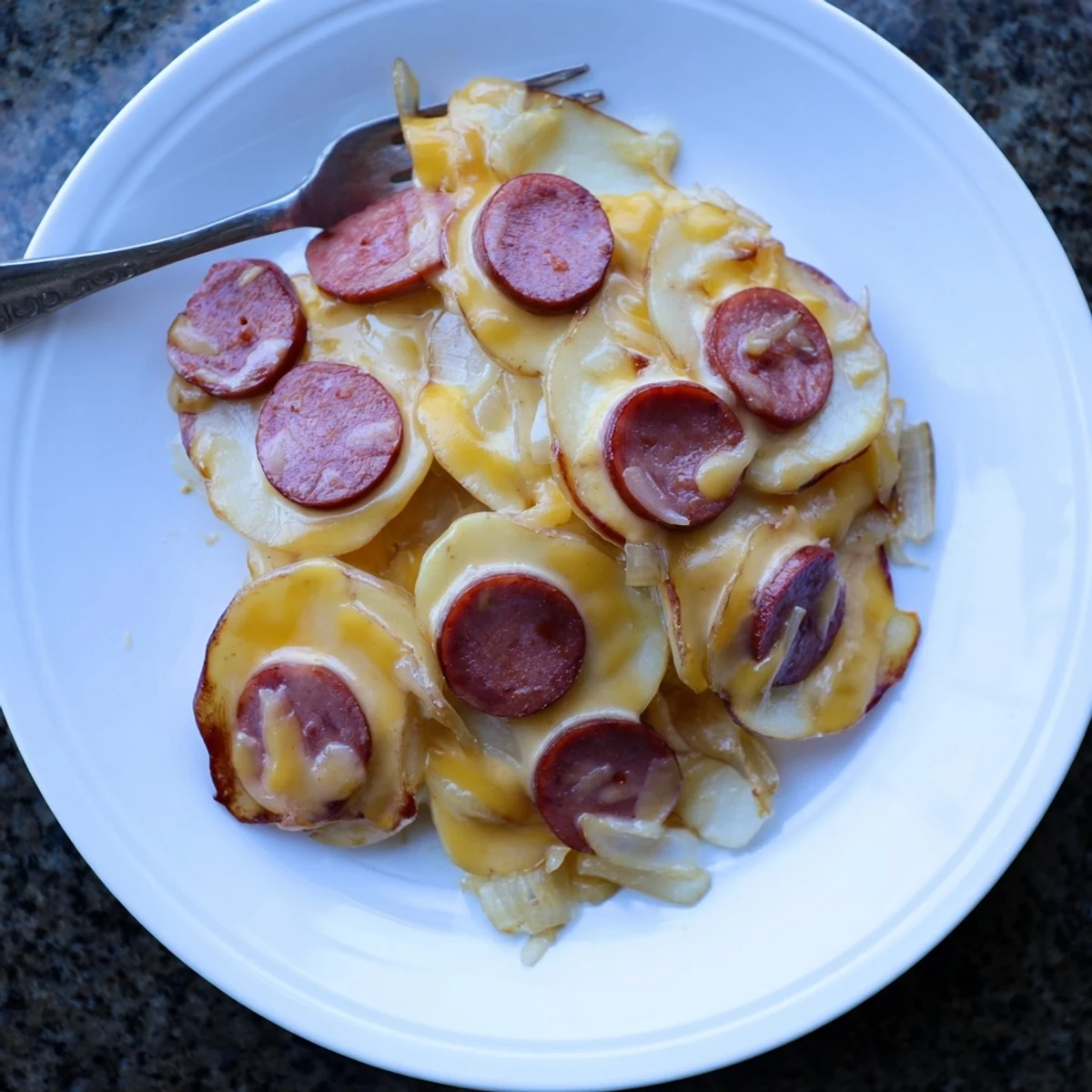 Slow cooker scalloped potatoes with kielbasa layered in creamy melted cheddar cheese sauce
