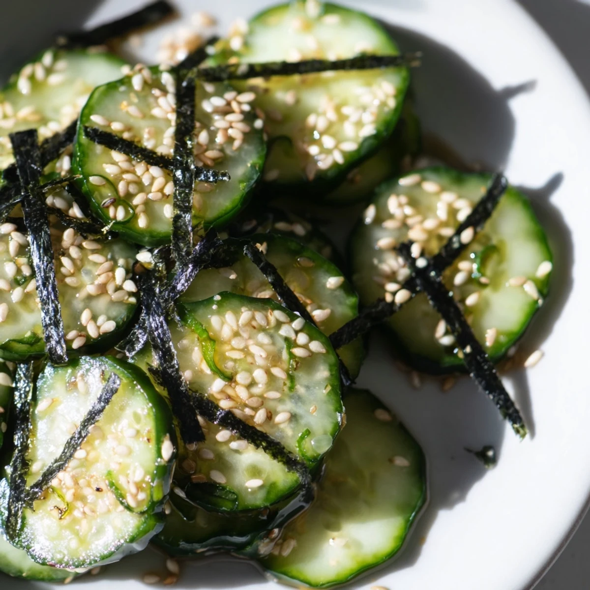 Sushi Cucumber Salad topped with crispy nori strips and toasted sesame seeds