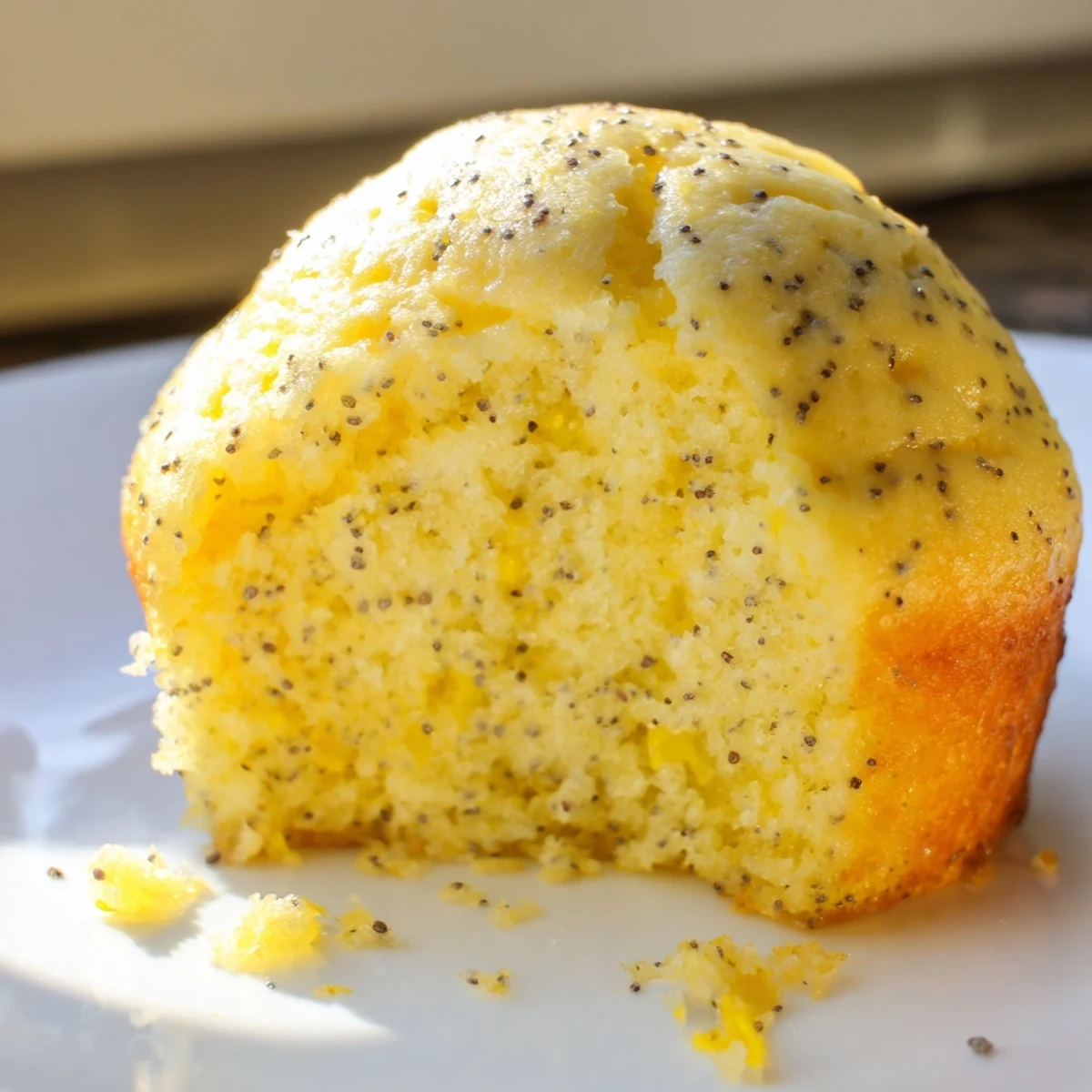 Golden lemon poppy seed muffins with domed tops fresh from the oven on a wire cooling rack
