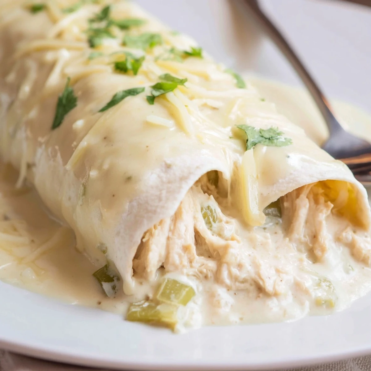 White Rotisserie Chicken Enchiladas bubbling in a baking dish, creamy melted cheese