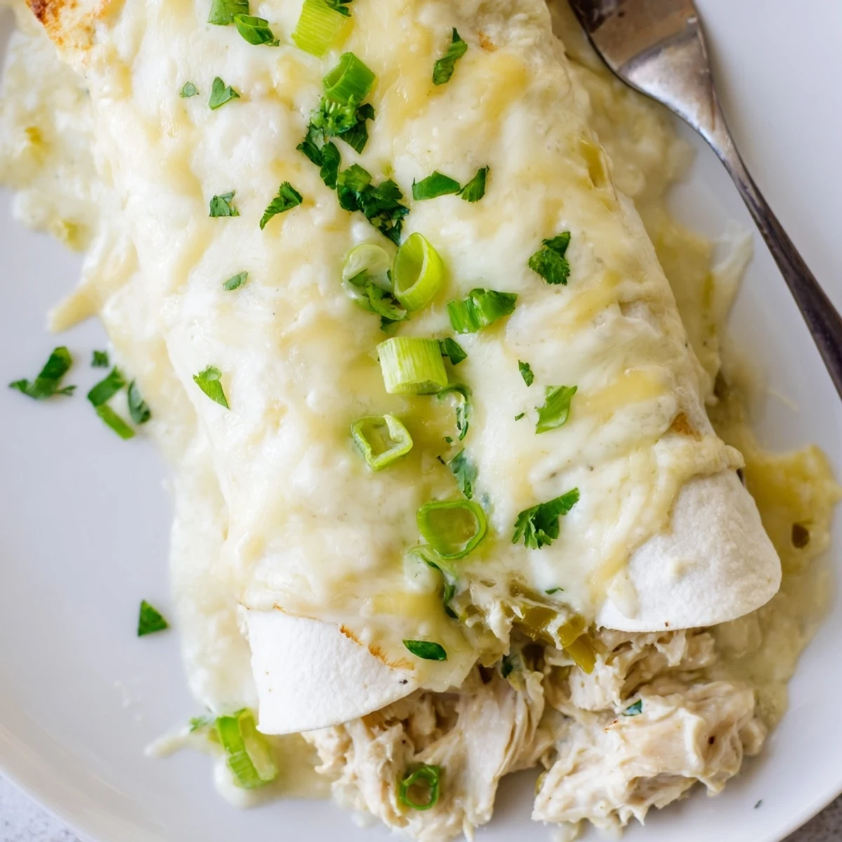 Sliced White Rotisserie Chicken Enchiladas topped with cilantro, served warm with rice
