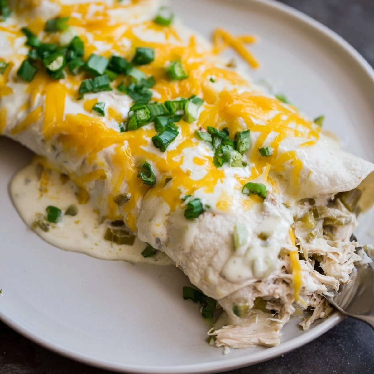 Golden edges on White Rotisserie Chicken Enchiladas, rich white sauce and gooey cheese