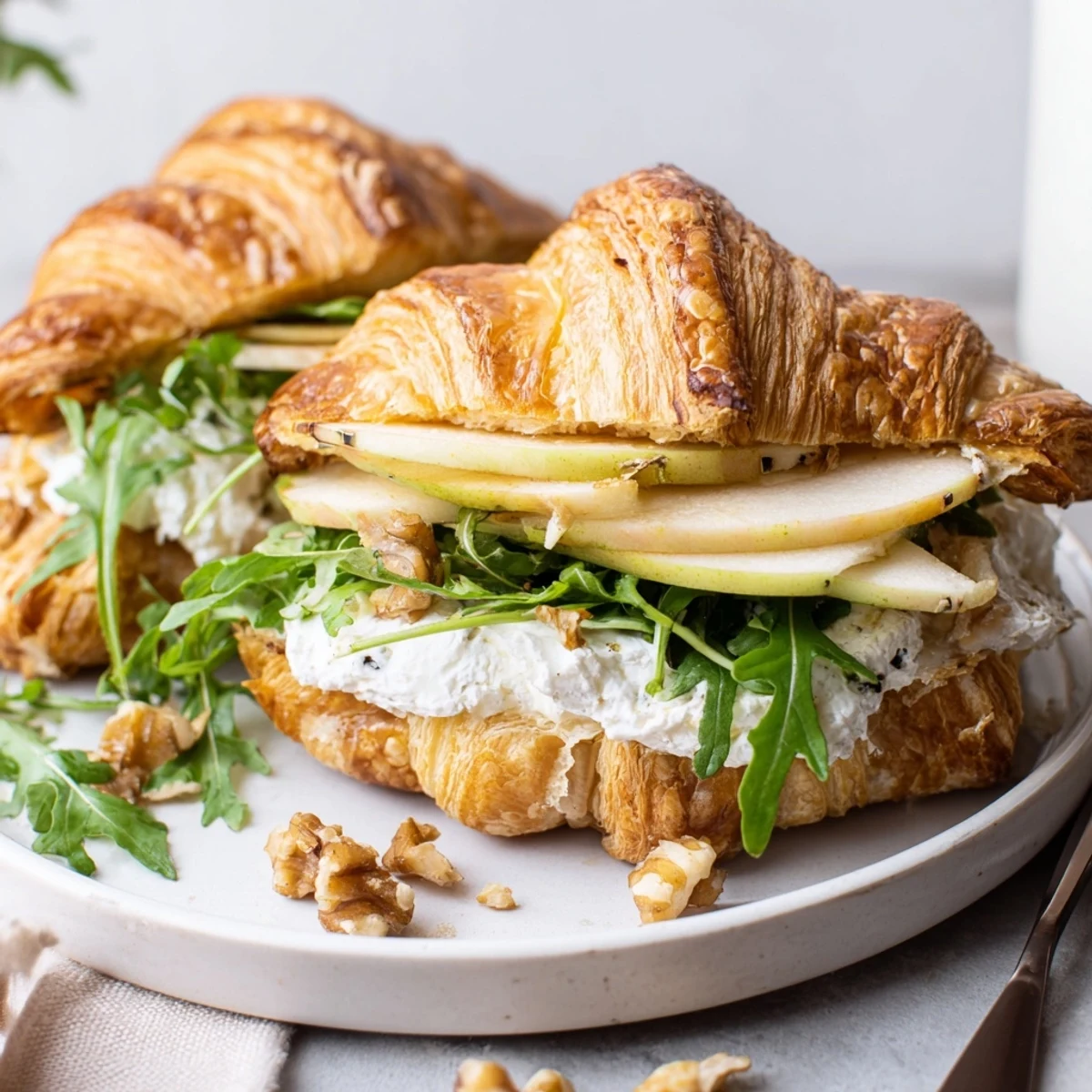 Handheld Apple Goat Cheese Croissant Sandwich served warm or chilled for elegant brunch