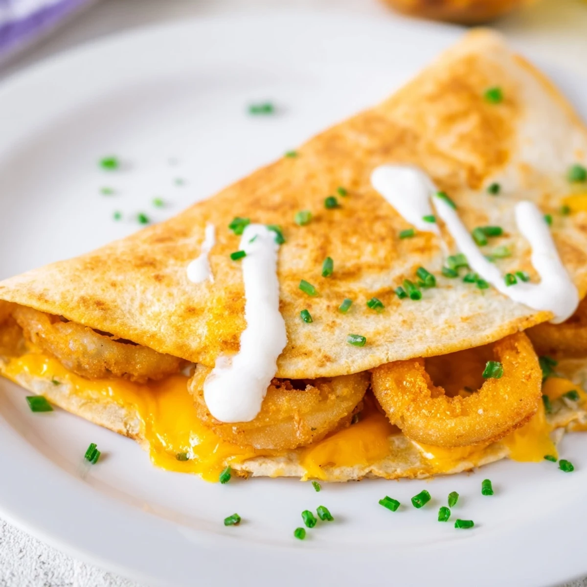 Golden quesadilla stuffed with crispy onion ring chips and melted cheddar mozzarella cheese