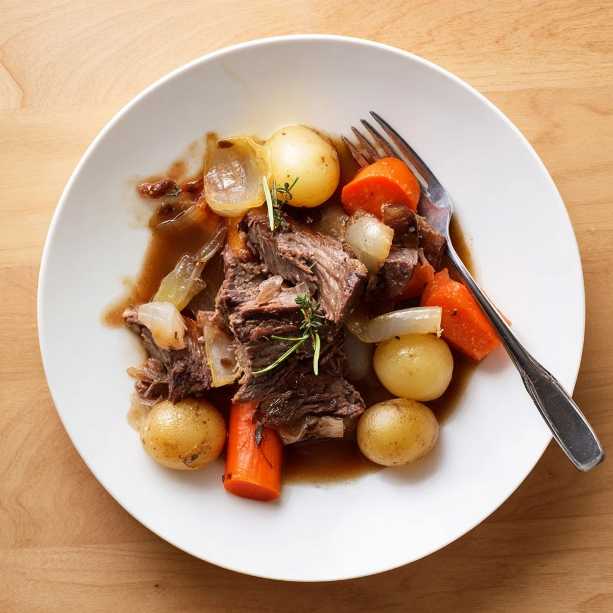 Comfort food herb braised beef chuck roast plated with carrots and onions