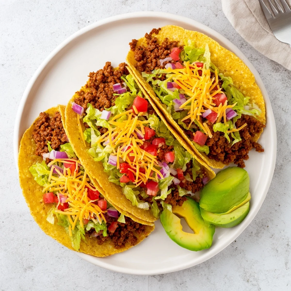Golden corn tortillas filled with juicy seasoned ground beef tacos topped with fresh homemade pico de gallo and melted cheese
