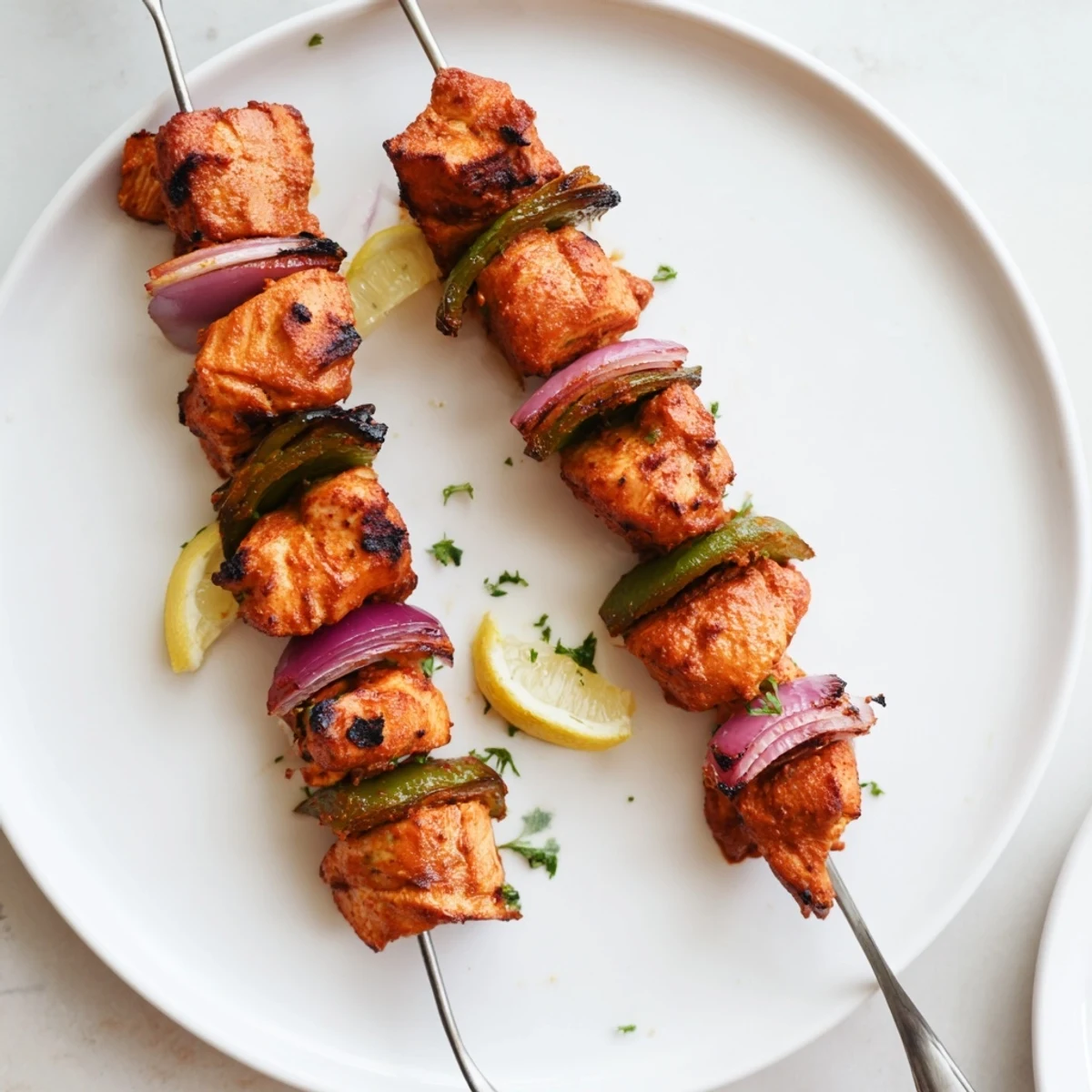Smoky Tandoori Chicken Tikka Skewers glazed with ghee, garnished with cilantro