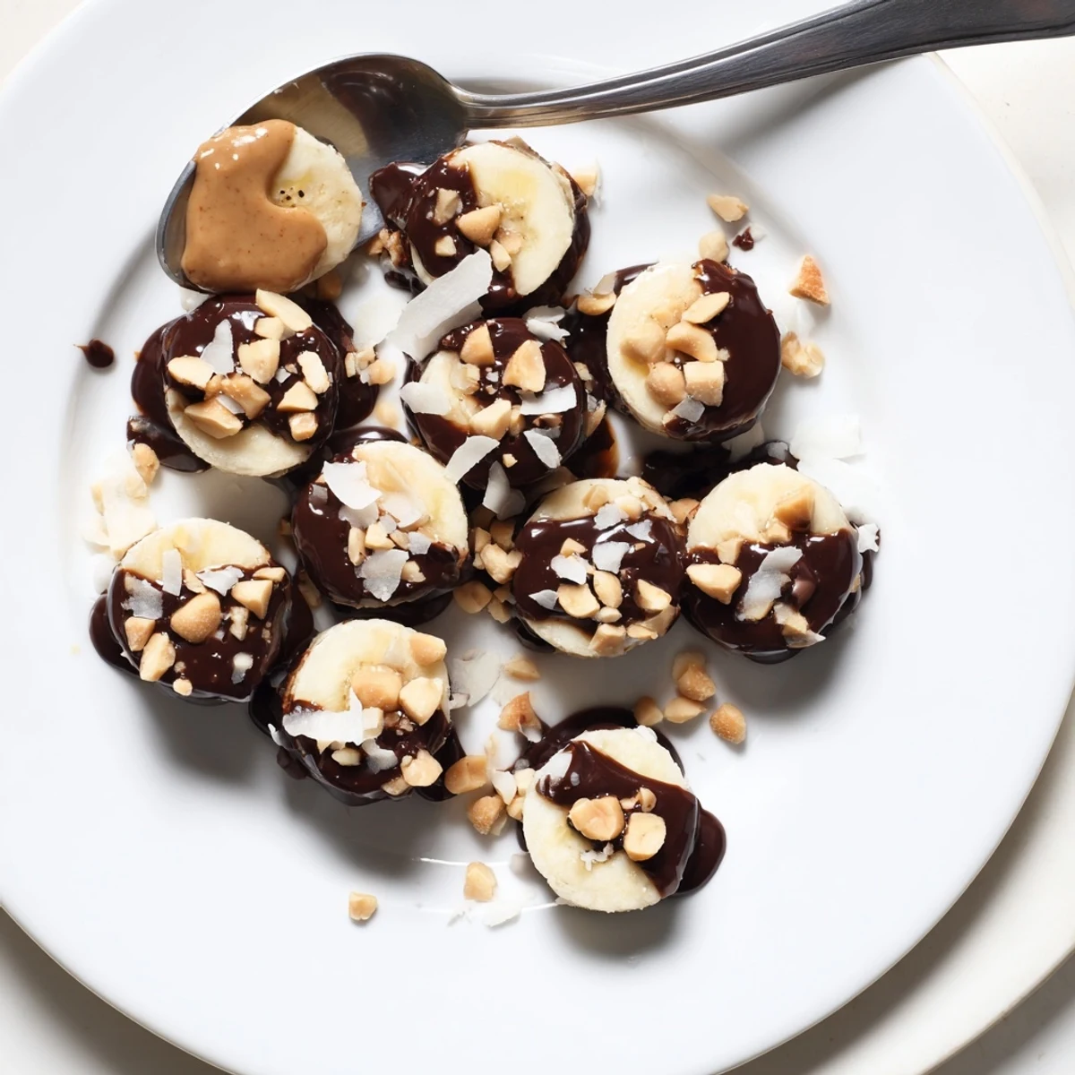 Chocolate Peanut Butter Banana slices drizzled with glossy chocolate, sprinkled roasted peanuts