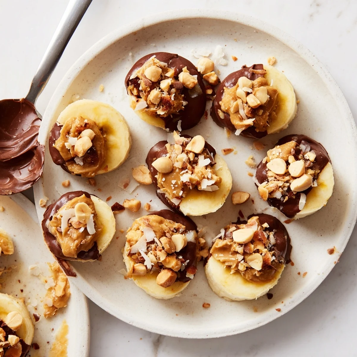 Chilled Chocolate Peanut Butter Banana bites on parchment, coconut flakes, melt-in-mouth