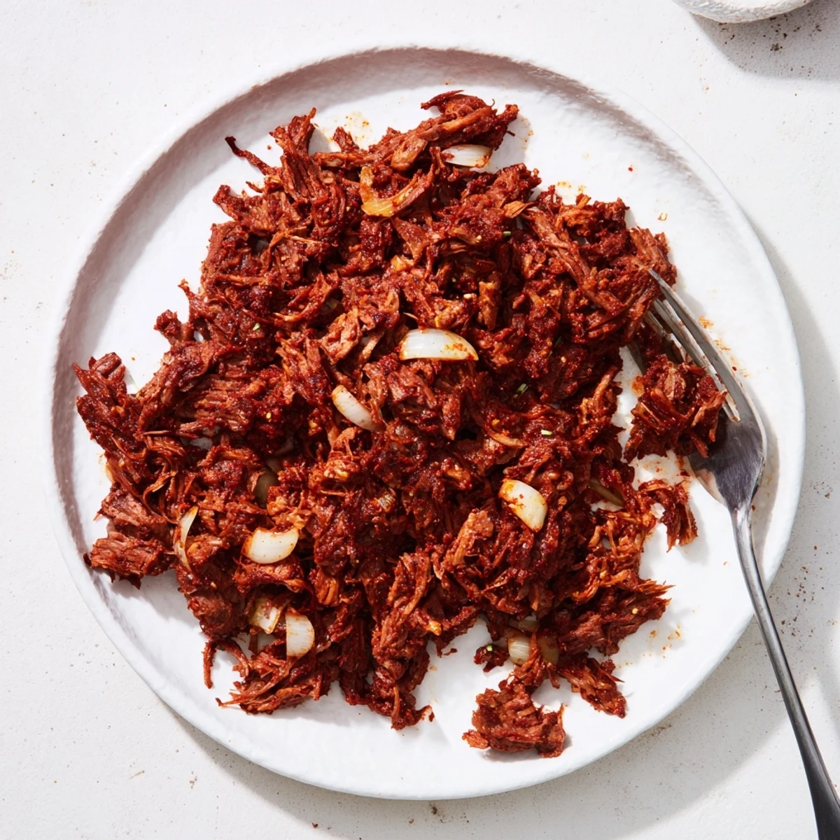 Golden Slow Cooker Beef Barbacoa tacos topped with fresh cilantro and white onion