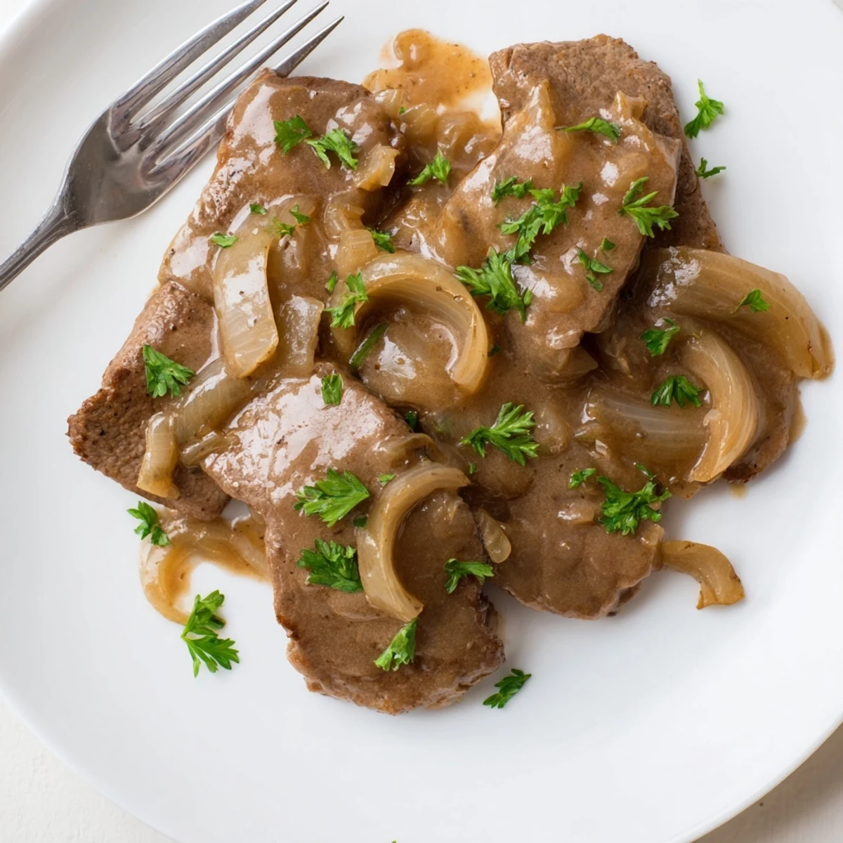 Golden brown country style smothered cube steak swimming in rich savory onion gravy