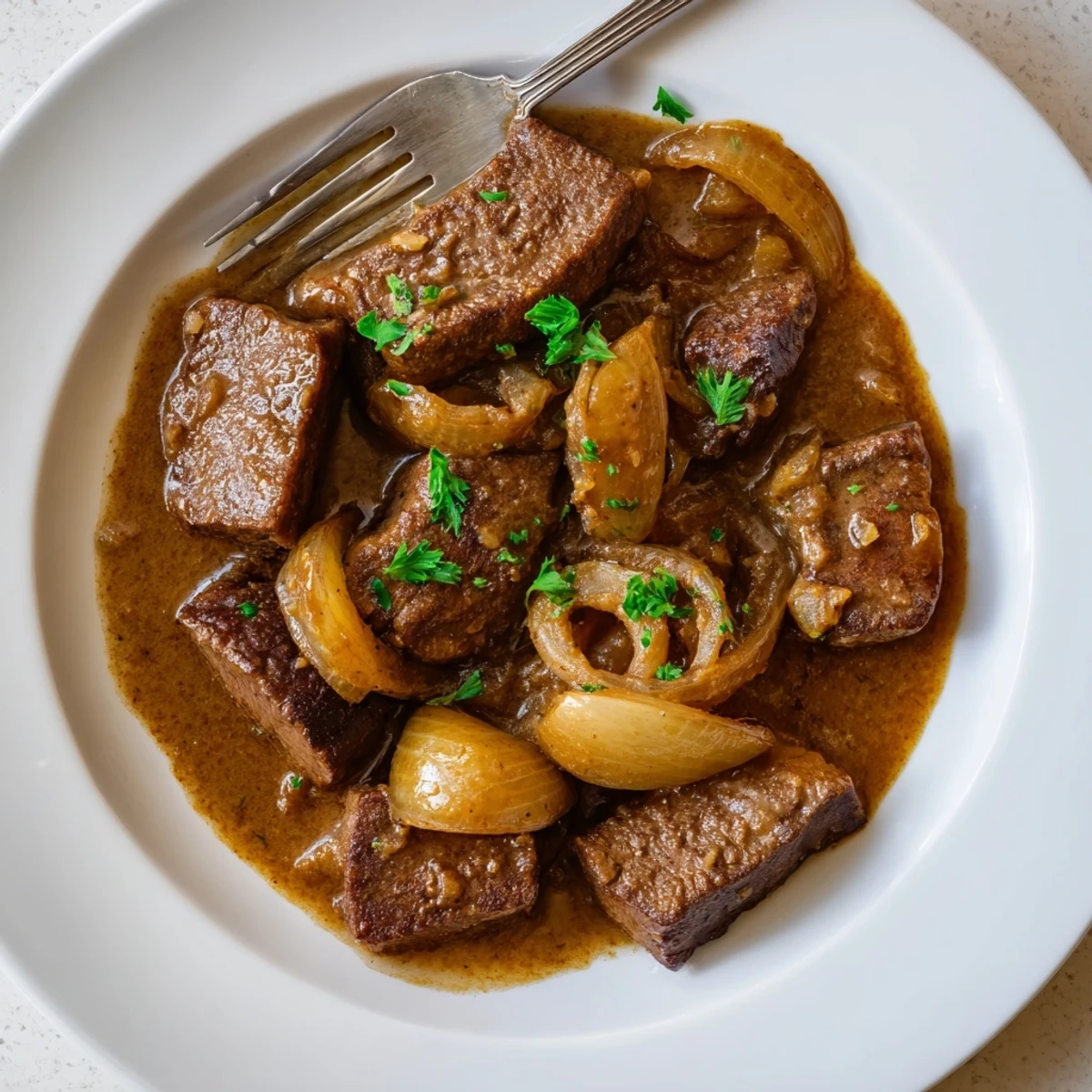 Tender southern cube steak plated over creamy mashed potatoes with fresh parsley garnish