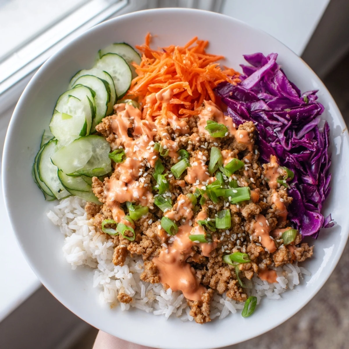 Ground Turkey Rice Bowls topped with colorful crisp vegetables and drizzled Bang Bang Sauce