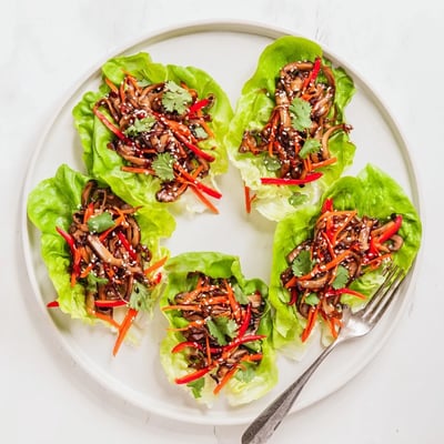 Savory Shiitake Mushroom Lettuce Wraps served warm with a drizzle of sesame sauce.
