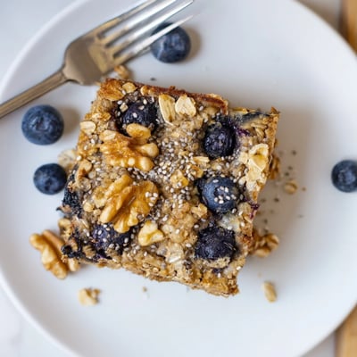Serving suggestion for the High Protein Banana Blueberry Breakfast Bake with a drizzle of honey.