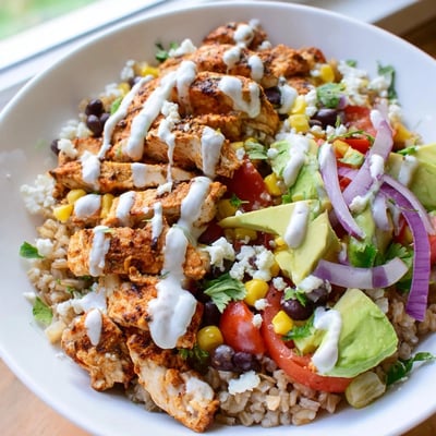 Spiced chicken strips nestled over fluffy rice with black beans, corn, and crumbled cotija cheese